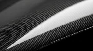 Close-up of carbon fiber body panel on a sports car, a key component for reducing weight and enhancing performance